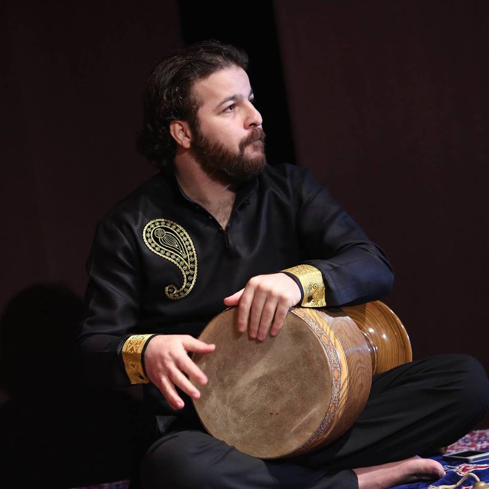 Sina Fakhroddin Ghaffari, seated, holding a tombak.