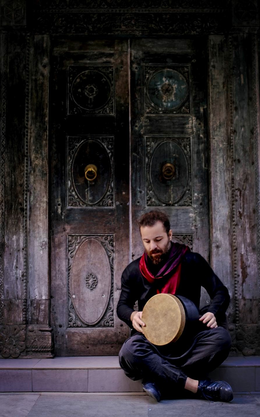Sina Fakhroddin Ghaffari, seated, holding a tombak.
